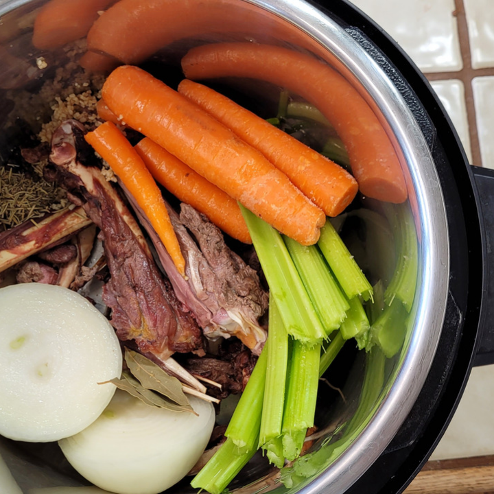 instant pot with turkey bones, carrots, celery, onion, bay leaves